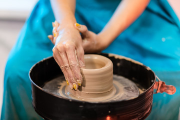 woman potter hands makes on the pottery wheel clay pot, close up. Potter's wheel. Pottery concept. - 372846071