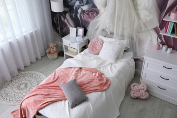 Teenage girl's room interior with comfortable bed and floral wallpaper. Idea for stylish design © New Africa