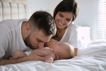 Obraz na płótnie Canvas Happy couple with their newborn baby at home