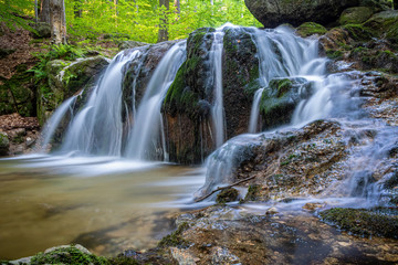 Fototapeta na wymiar Long exposure of stream waterfalls in summer forest