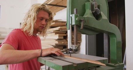 Caucasian male surfboard maker working in his studio and making a wooden surfboard - Powered by Adobe