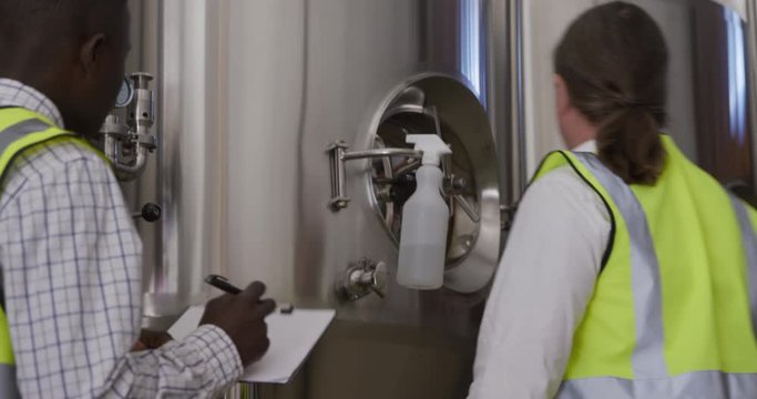 Caucasian and African American man working in a microbrewery