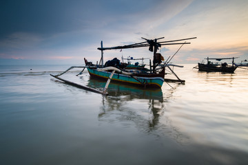 Fototapeta na wymiar traditional fishing boat leaning on the beach in the morning tuban east java
