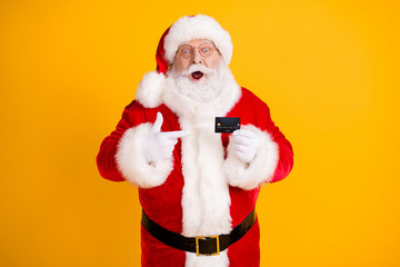 Grey white beard hair santa claus big belly point finger credit card impressed x-mas eve noel magic miracle christmas discount party wear cap white gloves isolated bright shine color background