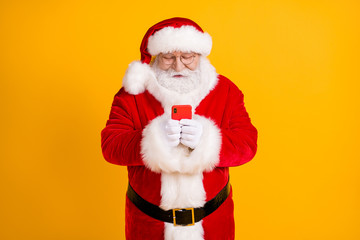 Photo north-pole fairy overweight grey beard santa claus use smartphone follow season shopping tradition x-mas sales discount wear cap headwear isolated bright shine color background