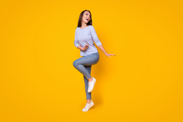 Fototapeta na wymiar Full length body size view of her she nice attractive carefree cheerful cheery girl jumping having fun dancing cozy comfort clothes wear isolated bright vivid shine vibrant yellow color background