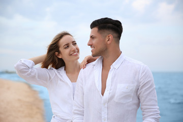 Obraz premium Happy couple having romantic walk on beach