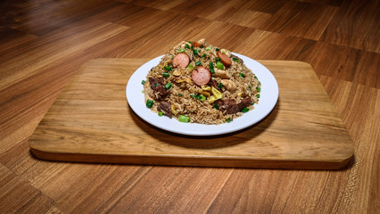 Peruvian food arroz chaufa, plate of fried rice with vegetables and different meats.