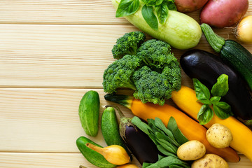 Set of various vegetables and herbs on a light wooden background