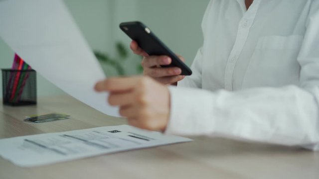 The hand uses the phone to scan the QR code to receive a discount from paying electricity bills at the office