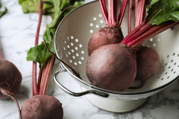 Raw ripe beets on white marble table