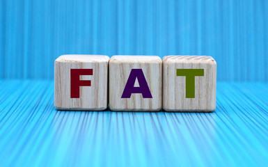 concept word FAT on cubes on a blue background