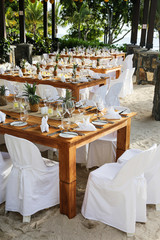 Table layout set up on a beach for an event.
