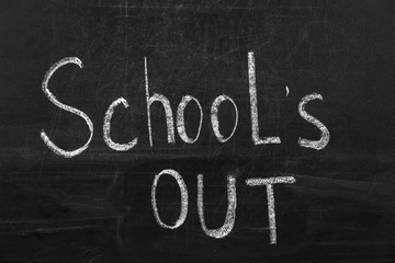 Obraz premium Text School's Out written on black chalkboard. Summer holidays