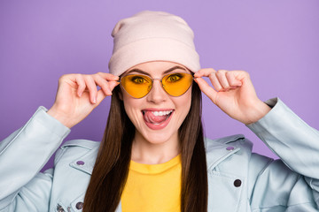 Portrait of positive cheerful youth girl imagine yummy sweet dessert lick tongue teeth touch modern specs wear casual style clothes isolated over purple color background