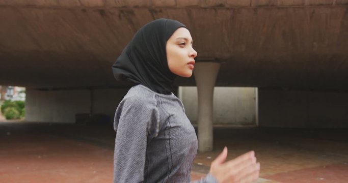 Side view of woman wearing hijab running 