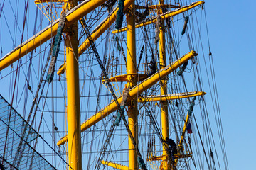 Rigging equipment of a sailing ship on a summer sunny day against a blue sky.