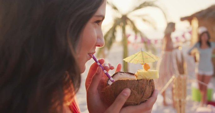 Caucasian woman drinking a cocktail on the beach 