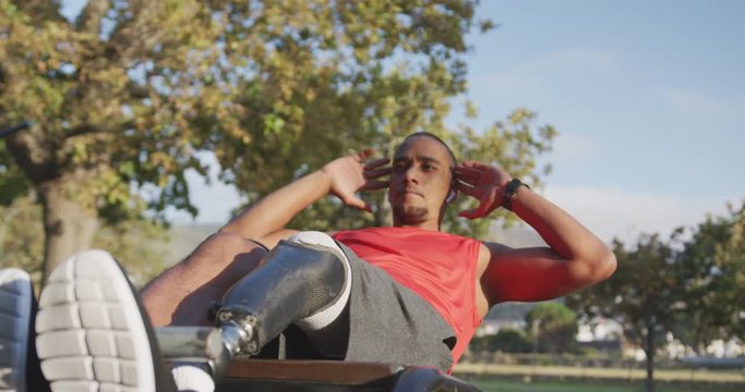 Side view man with prosthetic leg doing abs