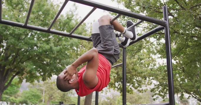 Side view man with prosthetic leg doing abs suspended in the air