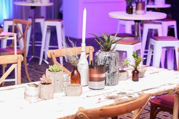 flowers, succulents and candles set up on a hand painted table.