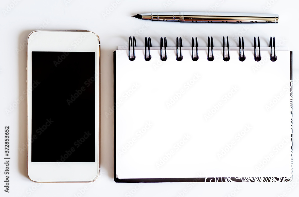 Poster blank notepad with smart phone and pen on the white table. view from above