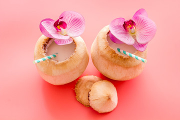 Fresh coconut with straw tropical drink and orchid flower, top view copy space