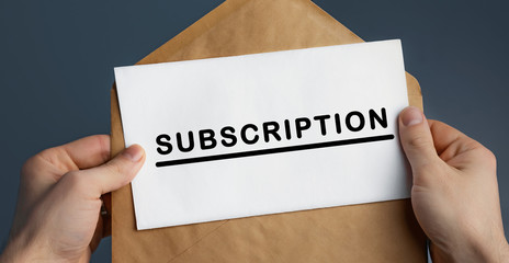 Cropped view of man holding craft envelope with text SUBSCRIPTION on blue background