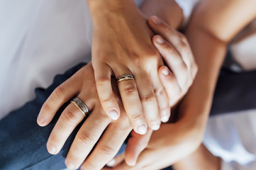 close-up portrait of the bride and groom. They hug their arms. Wedding rings on their hands