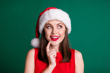 Closeup photo of attractive charming x-mas party lady look side up empty space arm chin dreamer wait miracle magic fireworks watch sky wear santa cap isolated green pastel color background