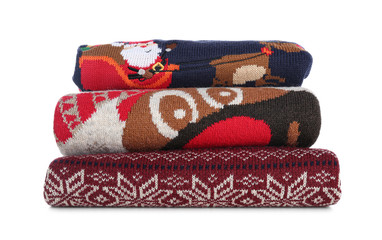 Stack of warm Christmas sweaters isolated on white