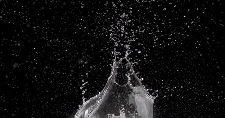 water rising up from the center of a black background.