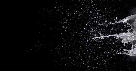 burst of water coming from the right side of the black background.