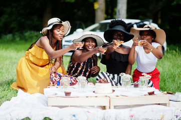 Group of african american girls celebrating birthday party and clinking glasses outdoor with decor.