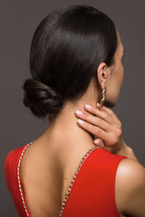 Obraz premium A brunette with a haircut on her head. Smooth hair is gathered in a bump. hairstyle hair bun