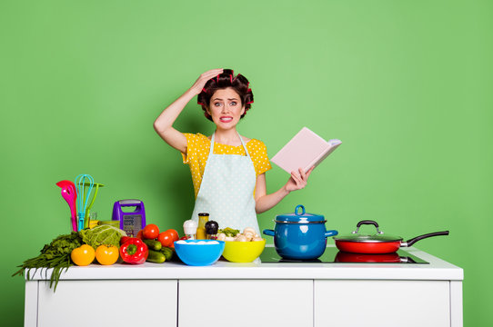 Oh No I Cant Choose Decide What Cook. Confused Frustrated Girl Hold Cook Book Touch Hand Head Wear Hair Rollers Yellow Dotted T-shirt Isolated Over Green Color Background