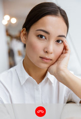 Screenshot of attractive young asian businesswoman looking at camera