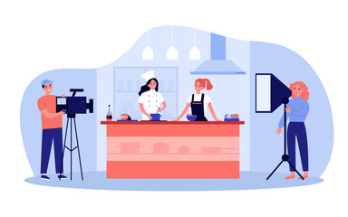 Popular cooking show concept. Camera man and stage manager shooting smiling chefs cooking and talking at kitchen counter. For TV show production, television, coking contest topics