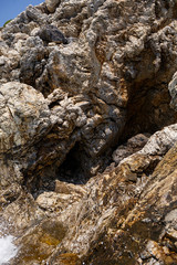 Waves with foam and splashing water. The wave crashes into the rocks on the shore