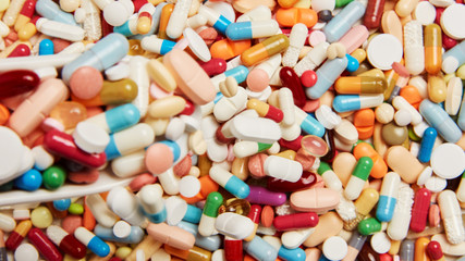 Fototapeta na wymiar Arznei wird auf viele bunte Medikamente gekippt