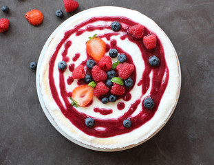 Top view of whole cheesecake with berries and coulis on top