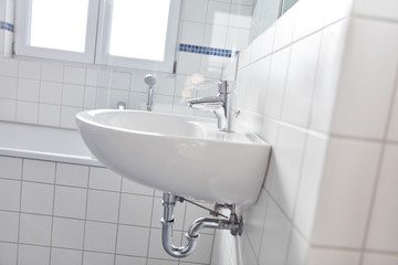 Wei0ße Fliesen im Badezimmer mit Waschbecken und Wanne