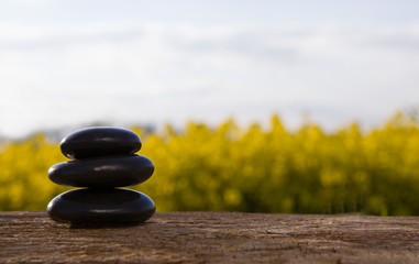 Stack of zen stones on abstract nature green and yellow summer background.