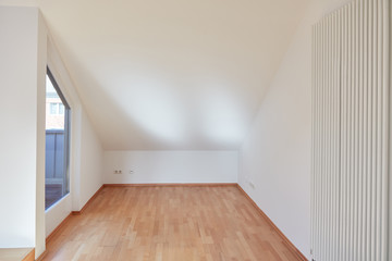 Leerer Raum mit Dachschräge in Dachgeschosswohnung