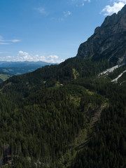 Fototapeta premium Aerial view of coniferous forest spruce trees on highland, Dolomites Alpine mountains. South Tyrol landscape Italy Europe. Summer. Travel