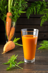 Natural carrot juice with pulp sugar-free in glasses on a wooden table