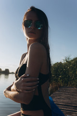 Young woman portrait outdoor in summer in sun glasses in water