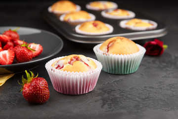 Strawberry muffins with fresh strawberries on dark concrete background