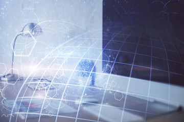 Double exposure of desktop with computer and world map hologram. International data network concept.