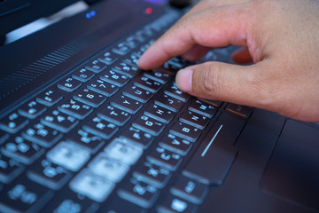 man typing on a laptop keyboard